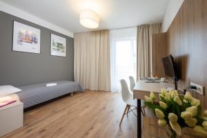 a hotel room with a bed and a desk with a computer at Wolska Residence in Warsaw