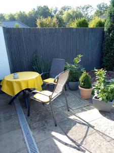 une table et des chaises jaunes assises sur une terrasse dans l'établissement Sommerheide, à Bad Bevensen