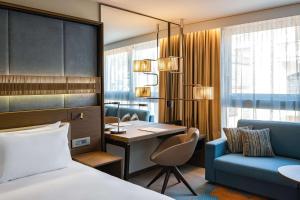 a hotel room with a bed and a desk and a chair at Hyatt Regency Malta in St. Julianʼs