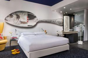 a bedroom with a bed and a fish painting on the wall at Andaz Amsterdam Prinsengracht - a concept by Hyatt in Amsterdam