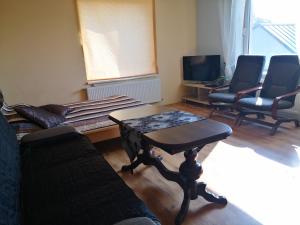 Kambario nuoma su bendru vonios kambariu في كاوناس: غرفة معيشة مع أريكة وكراسي وطاولة