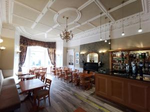 a dining room with a large wooden table and chairs at The Haymarket Hotel in Edinburgh