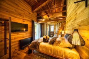 una camera con un letto su una parete in legno di BAITA MAORE luxury rooms & Spa a Làconi