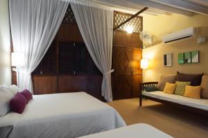 a bedroom with two beds and a window and a couch at Carnarvon House in George Town