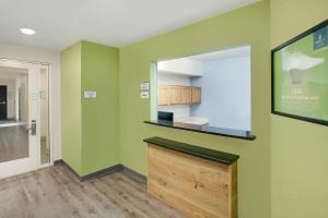 a room with green walls with a counter and a door at WoodSpring Suites Texas City in Texas City
