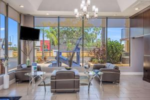 ein Wohnzimmer mit Sofas und einem Flachbild-TV in der Unterkunft Rodeway Inn Port Richey North in Port Richey