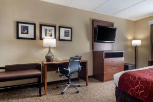 a hotel room with a bed and a desk with a computer at Comfort Suites Woodstock in Woodstock