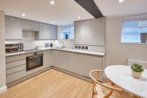 a kitchen with white cabinets and a table and a window at Host & Stay - Staffordshire Hideaway in Whitby