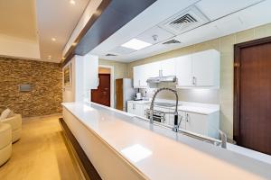 a kitchen with white cabinets and a counter top at Large 2 Beds Partial Marina View, J Tower II in Dubai