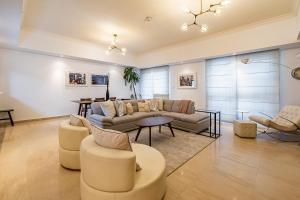 a living room with a couch and a table and chairs at Large 2 Beds Partial Marina View, J Tower II in Dubai