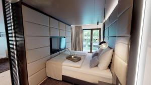 ティメンドルファー・シュトラントにあるWhite Pearl Apartment 1.11のベッドとテレビが備わる客室です。