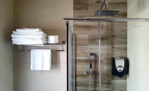 a bathroom with a glass shower stall with towels at Hostal Boutique Casa del Mar Altea in Altea