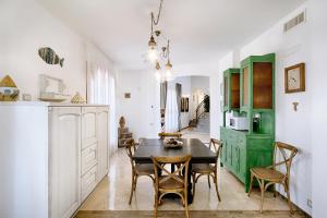 a kitchen and dining room with a table and chairs at Villa Domus Petraianca in Marina di Ragusa