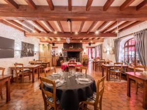 a dining room with tables and chairs and a fireplace at La Vieille Auberge du Lac in Saint-Agnan