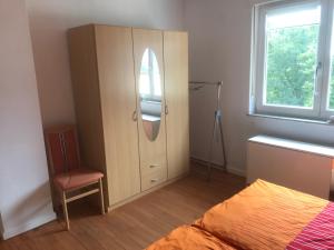 1 dormitorio con armario, cama y ventana en Ferienwohnung in Maring-Noviand en Maring-Noviand