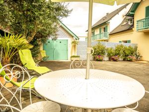 a white table and chairs with an umbrella at En so de Bourdet in Lourdes