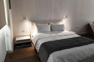 sypialnia z dużym łóżkiem z białą pościelą i poduszkami w obiekcie Feel the Sea Studio w mieście Palaión Tsiflíkion