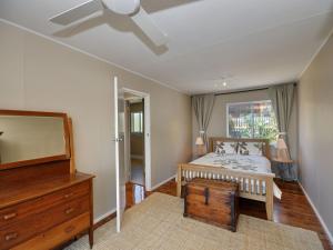 Schlafzimmer mit einem Bett, einer Kommode und einem Spiegel in der Unterkunft Riverwatch in Hawks Nest