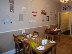 jadalnia z drewnianym stołem i krzesłami w obiekcie Kingsmere Guest House w mieście South Shields