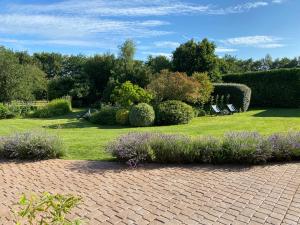 a garden with two lawn chairs and purple flowers at Old Hall Country Breaks in Tilney All Saints