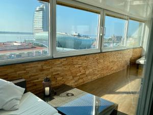 a room with a large window with a cruise ship at COAST HOUSE Havenquartier in Bremerhaven +49 photos