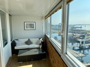 a living room with a couch and a large window at COAST HOUSE Havenquartier in Bremerhaven