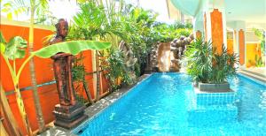 uma piscina num hotel com plantas e uma piscina em JOOPLAND Luxury Pool Villa Pattaya Walking Street 6 Bedrooms em Pattaya Sul