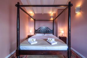 a bedroom with a canopy bed with two pillows on it at Villa Branca 6+2 in Krnica