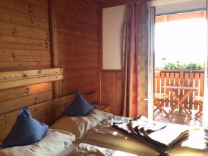 a bedroom with a bed and a window with a deck at Bio - Hotel - Alpengasthof Koralpenblick in Deutschlandsberg