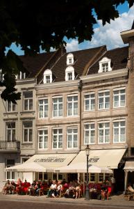 een groot gebouw waar mensen buiten zitten bij Le Theatre in Maastricht