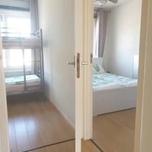 ein Schlafzimmer mit einem Bett und einem Etagenbett in der Unterkunft Ammophila 1 in Egmond aan Zee