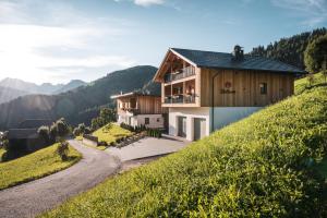 a house on the side of a hill with a road at Batacör - Natures Heartbeat in San Vigilio Di Marebbe