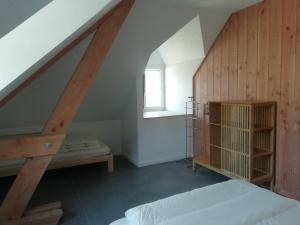 a attic room with a bed and a window at Gîte de Granit Noir in Besse-et-Saint-Anastaise