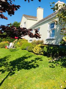 una casa con un patio con césped verde en Hillcrest farmhouse Bed & Breakfast, en Boyhollagh