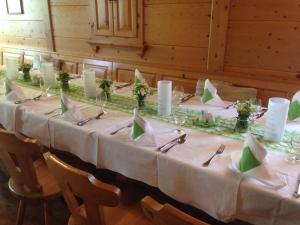 a long table with white table cloth and green napkins at Bio - Hotel - Alpengasthof Koralpenblick in Deutschlandsberg