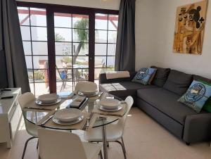 a living room with a couch and a table and chairs at Castillo Sol Bungalow in Caleta De Fuste