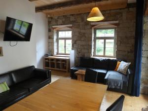 ein Wohnzimmer mit einem Sofa und einem Tisch in der Unterkunft "Meisterstube" - Hammergut Neidberg in Bielatal