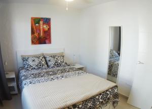 a bedroom with a bed and a painting on the wall at Castillo Sol Bungalow in Caleta De Fuste +41 photos