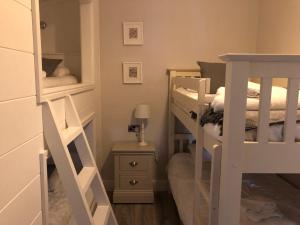 a room with two bunk beds with a ladder at 7 The Oaks in North Walsham