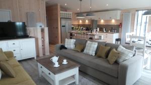 a living room with a couch and a table and a kitchen at 7 The Oaks in North Walsham