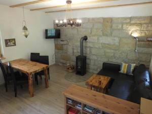 ein Wohnzimmer mit einem Sofa, einem Tisch und einem Kamin in der Unterkunft Waldhaus Bielatal in Bielatal