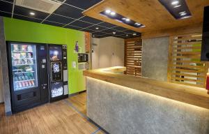 a bar with a soda machine in a restaurant at ibis budget Auxerre Centre in Auxerre