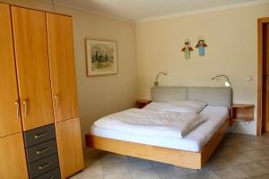 a bedroom with a bed and a wooden cabinet at Ferienwohnung Fanese in Flintsbach