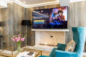 a living room with a flat screen tv on a wall at Kingfisher Hotel, Golf and Country Club in Milton Keynes