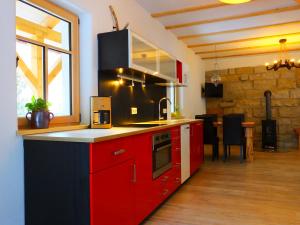 BielatalにあるWaldhaus Bielatalのキッチン(赤いキャビネット、カウンタートップ付)