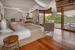 a bedroom with two beds and a bathroom with a tub at Lemala Wildwaters Lodge in Kangulumira