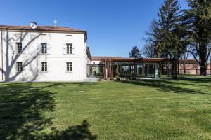 an exterior view of a large white house with a yard at Villa Cantoni Marca in Sabbioneta