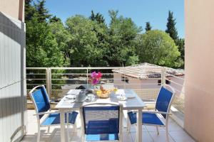 - une table et des chaises blanches sur la terrasse dans l'établissement Résidence Odalys Les Océanides, à La Londe-les-Maures