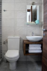 y baño con aseo blanco y lavamanos. en Sun Thalassa en Kavala