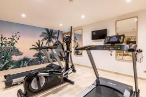 a fitness room with a treadmill and a tv at Paris d'Issy Hôtel Porte de Versailles in Issy-les-Moulineaux